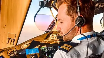 Pilot in cockpit, focused on flight