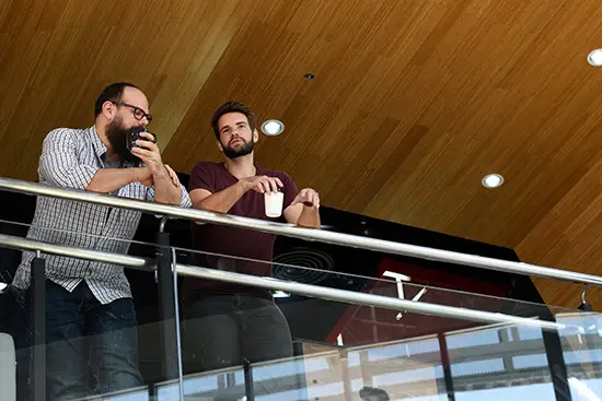 Two men chatting on a balcony during salesforce event