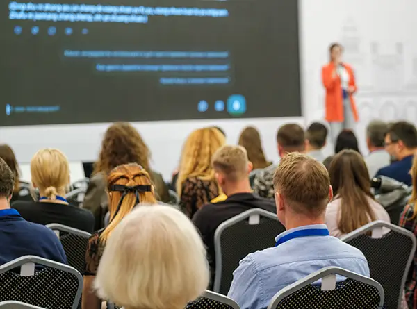 woman speaking in public with live translation on screen