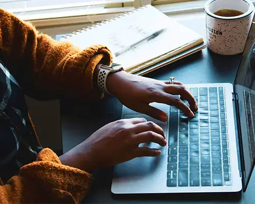 Woman working on a laptop speaking naturally while AI transforms their words into clear, professional, and well-structured text.
